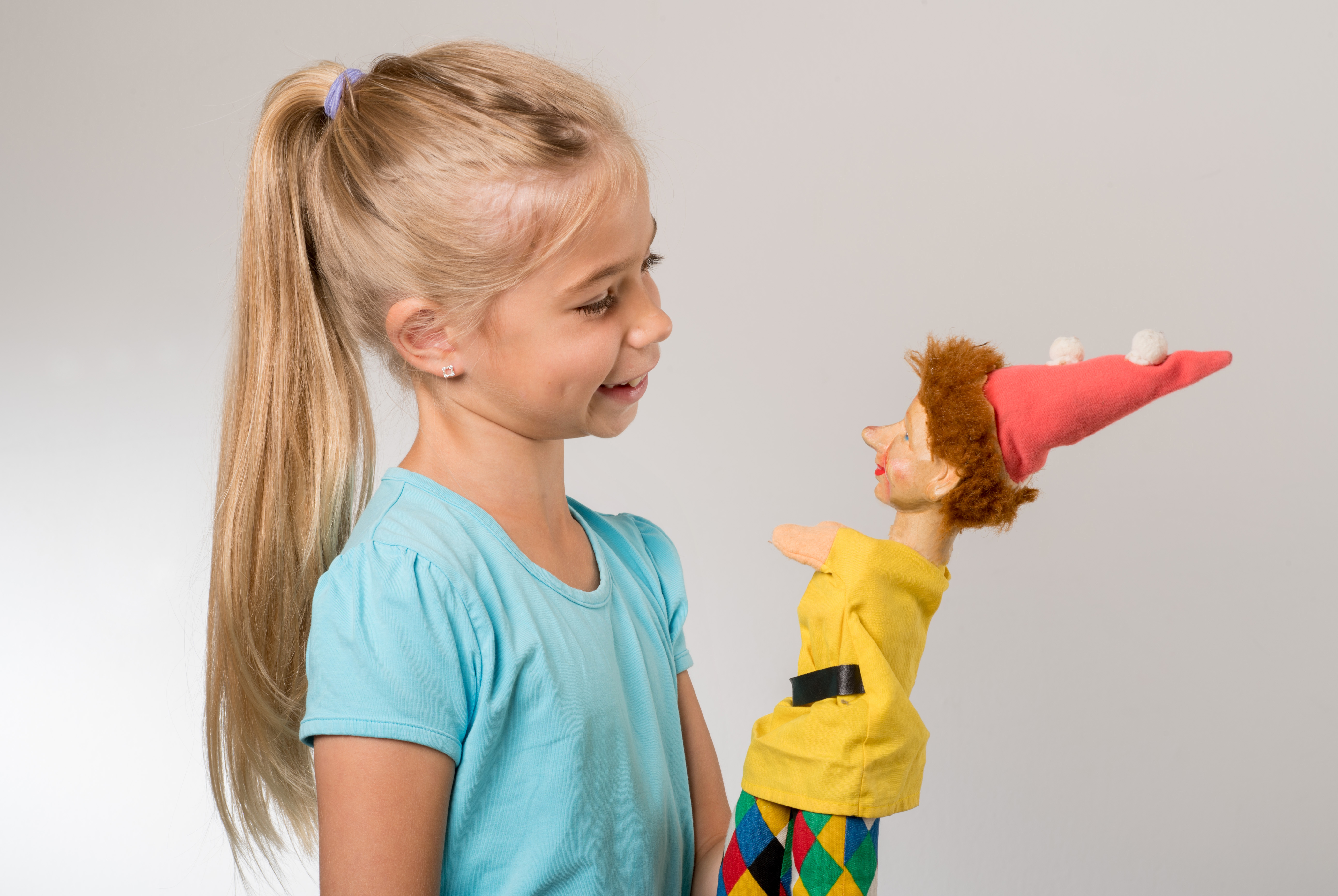 Kleines Mädchen mit einer Kasper-Handpuppe