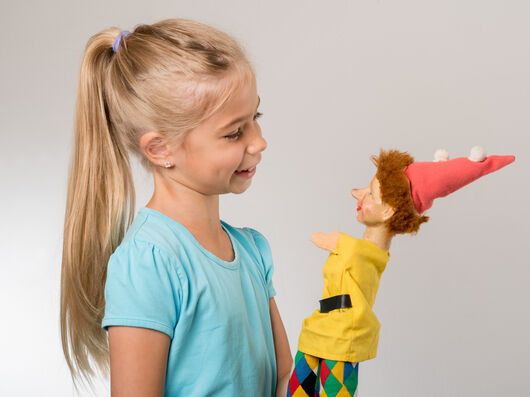 Kleines Mädchen mit einer Kasper-Handpuppe