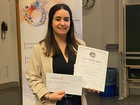 Dunkelhaarige junge Frau mit Auszeichnung in den Händen