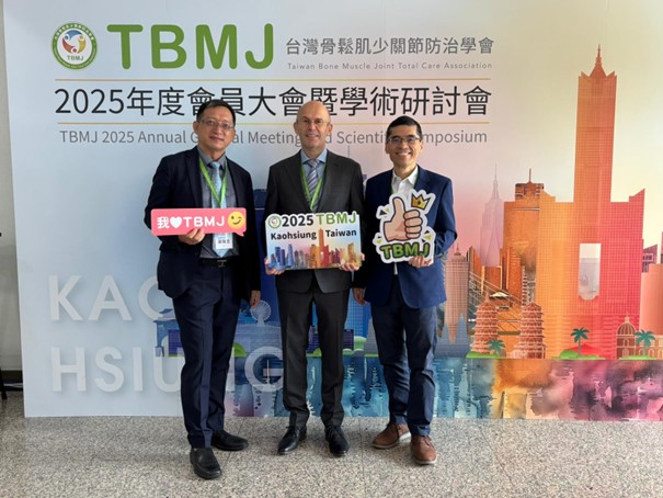 [Translate to Englisch:] Auf dem Foto sind drei Personen abgebildet, die vor einer Leinwand stehen. Man erkennt im Hintergrund die Buchstaben TBMJ. Die drei Männer tragen Anzüge und schauen in die Kamera.