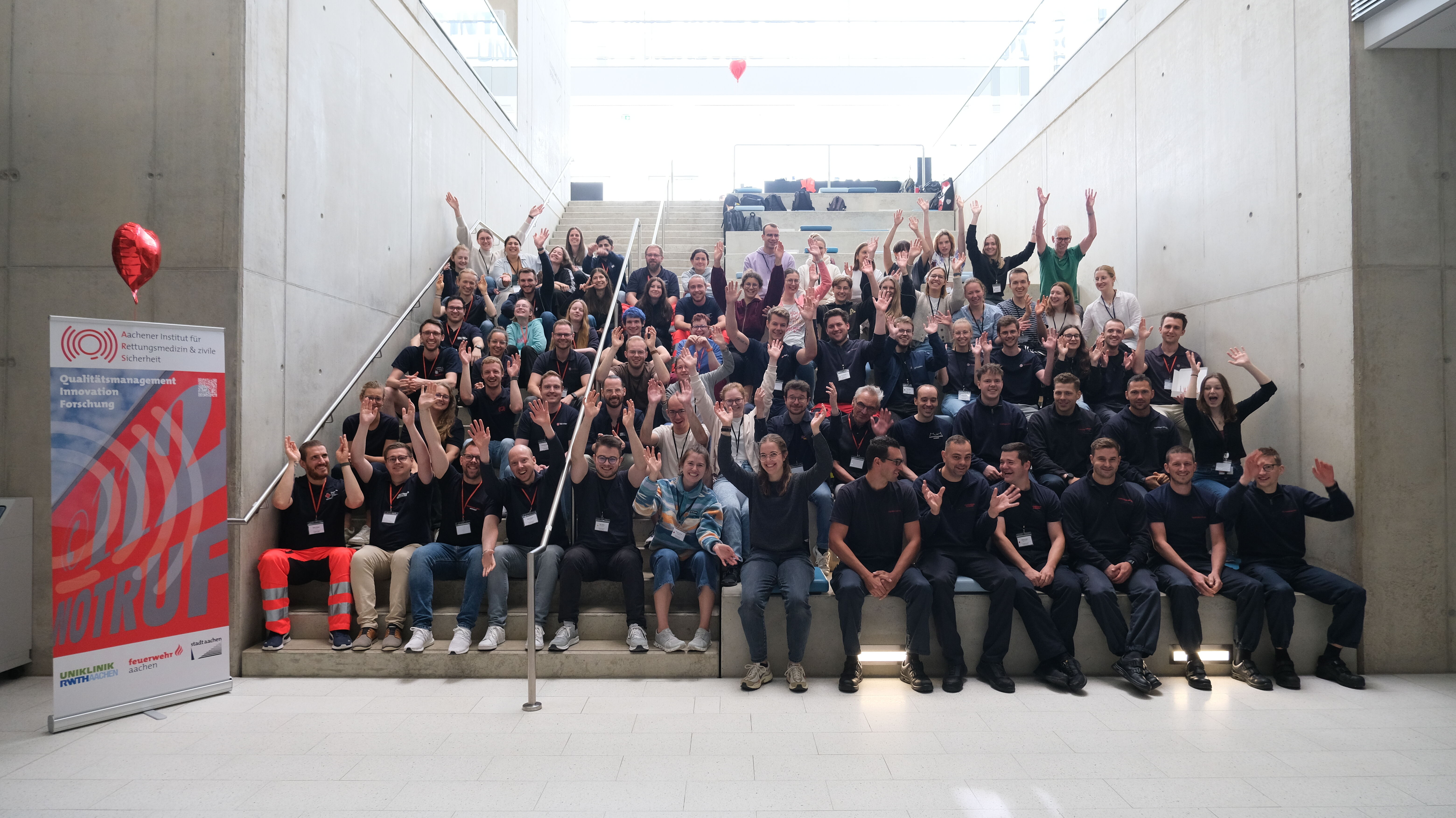 Eine große Gruppe Menschen sitzt auf einer Treppe und jubelt