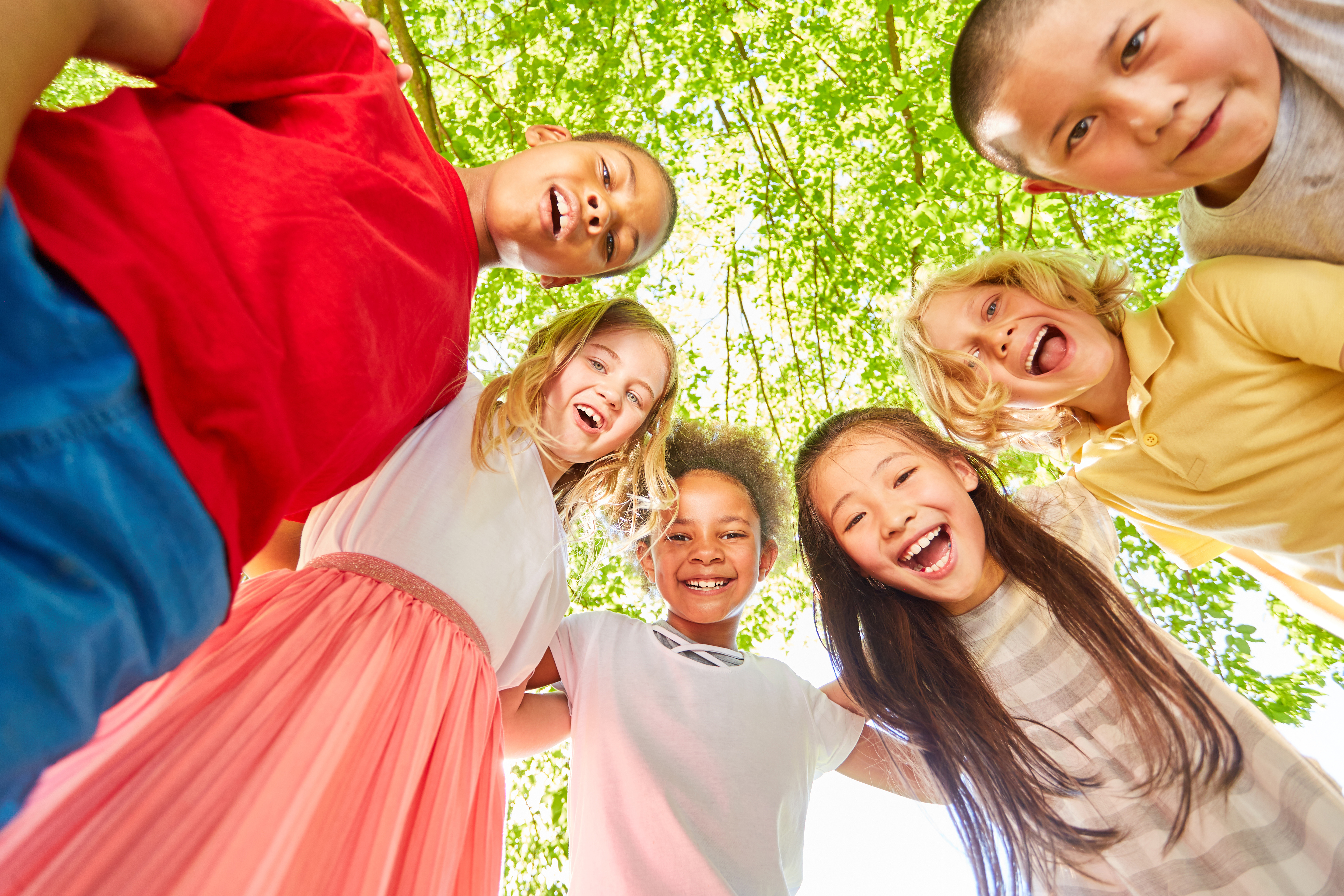 Kinder stehen im Kreis und lachen (im Wald)