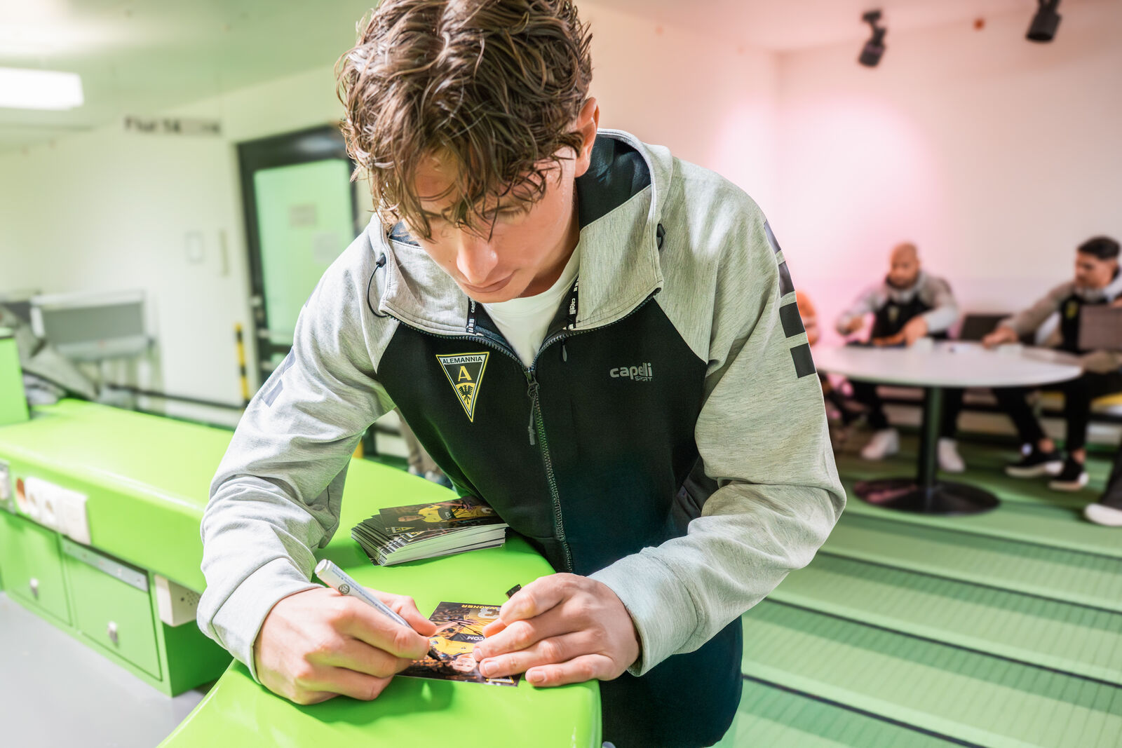 Spieler von Alemannia gibt Autogramm