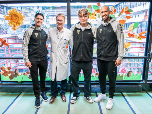 Gruppenfoto mit den drei Fußballern von Alemannia mit dem Klinikdirektor der Kinder- und Jugendmedizin 