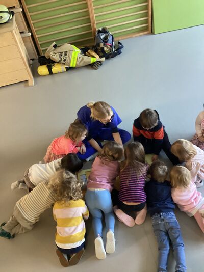 Kinder sitzen auf dem Boden im Kreis