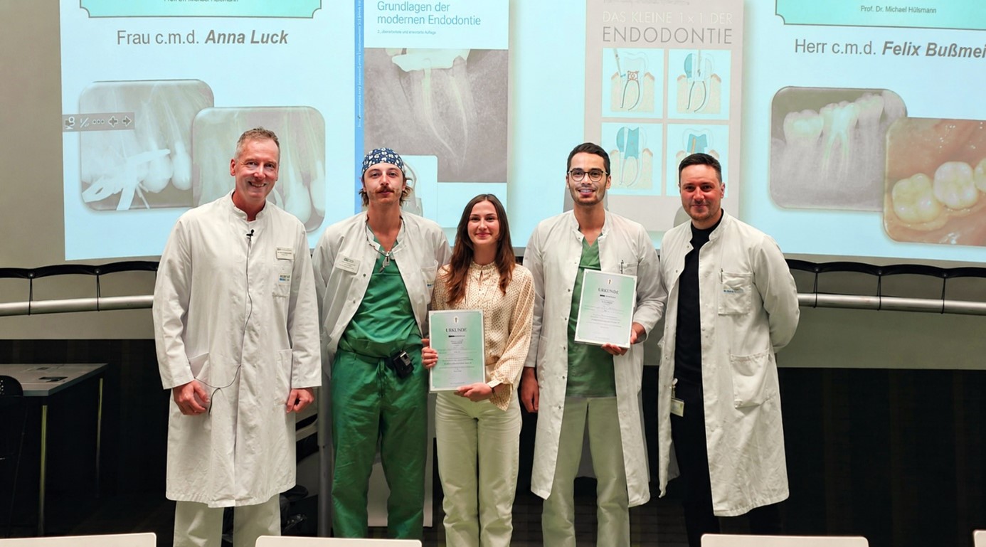 Überreichung der Urkunden der Fachzeitschrift „Endodontie“ an Anna Luck (Mitte) und Felix Buß-meier (2. von rechts) durch Klinikdirektor Univ.-Prof. Dr. Andreas Braun (links), Zahnarzt Dr. Tim Klomp (2. Von links) und Oberarzt Dr. Johannes-Simon Wenzler (rechts) haben die Studierenden im praktischen Kurs betreut.
